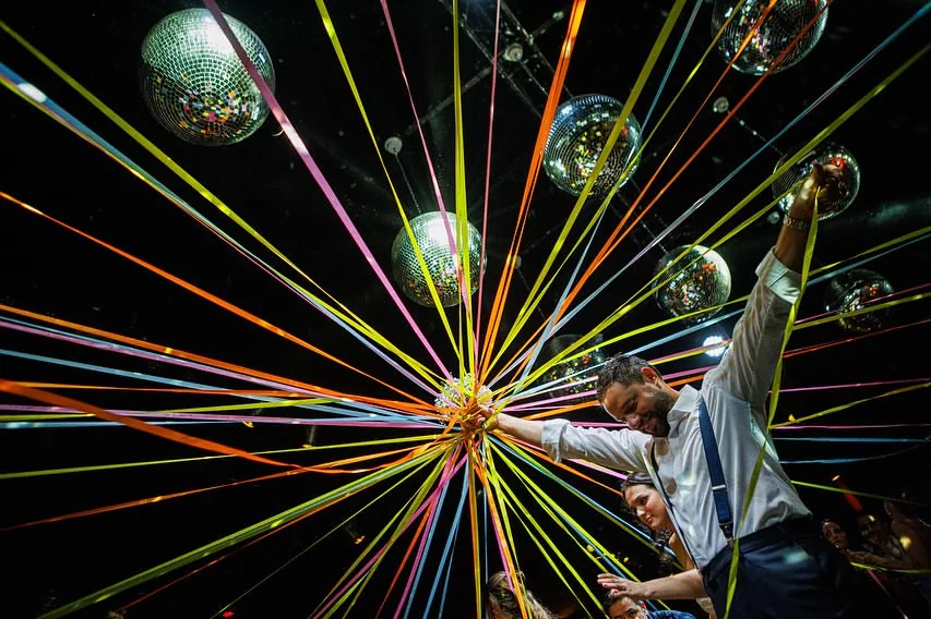 Haces de luz radiales desde esfera disco sobre los invitados