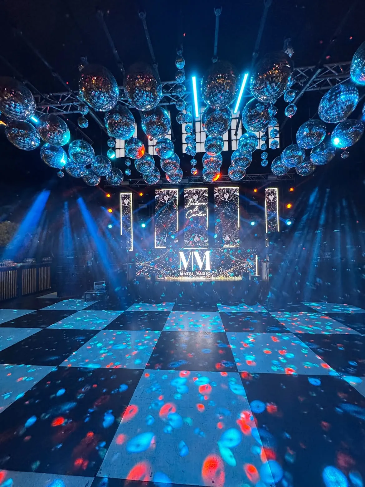 Montaje de escenario MatriMusic con esferas disco y pista damero iluminada